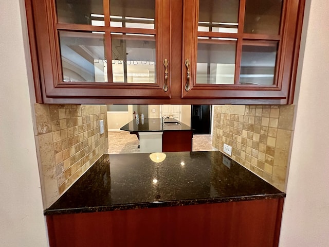 kitchen with dark stone counters and tasteful backsplash