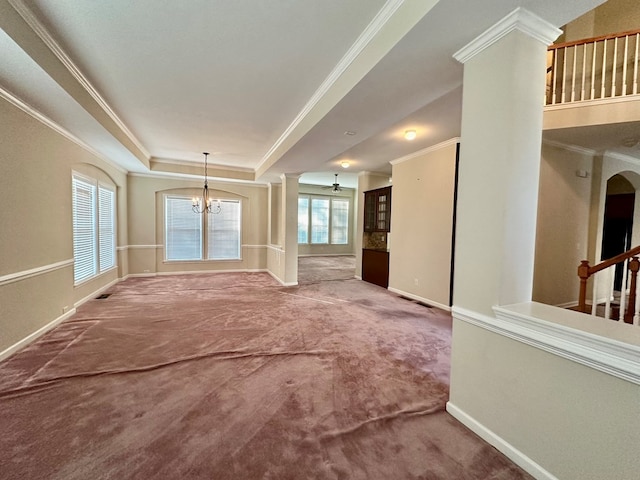 unfurnished living room with a healthy amount of sunlight, carpet floors, ornamental molding, and a chandelier