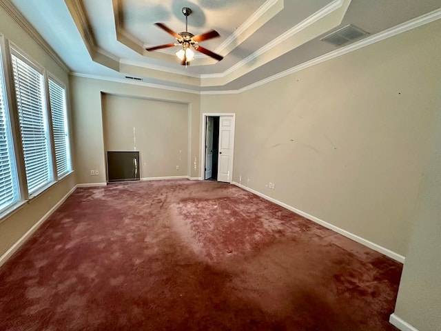 unfurnished bedroom featuring carpet, a raised ceiling, and ornamental molding