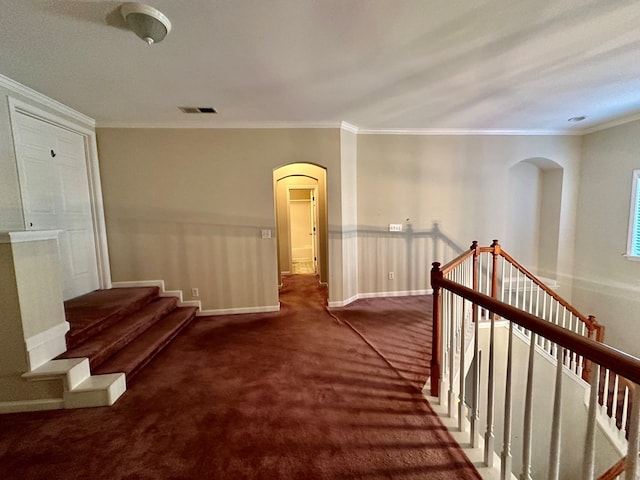 hallway with dark colored carpet and crown molding