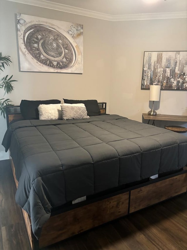 bedroom with crown molding and dark wood-type flooring