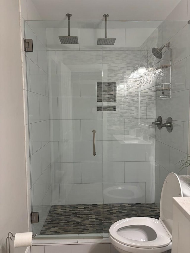 bathroom featuring toilet, vanity, and walk in shower