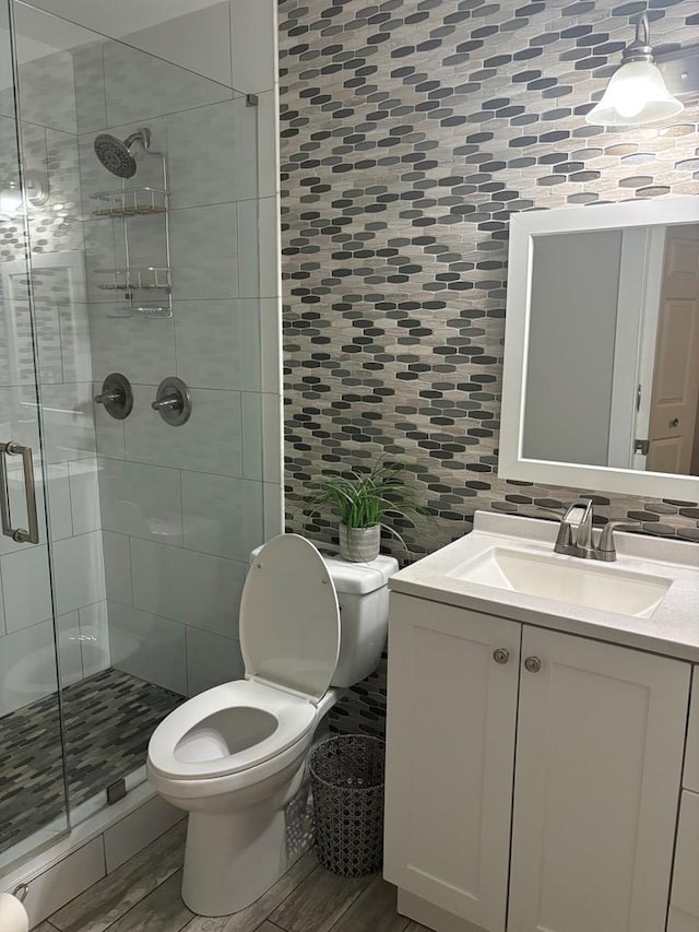 bathroom with hardwood / wood-style floors, vanity, toilet, and decorative backsplash