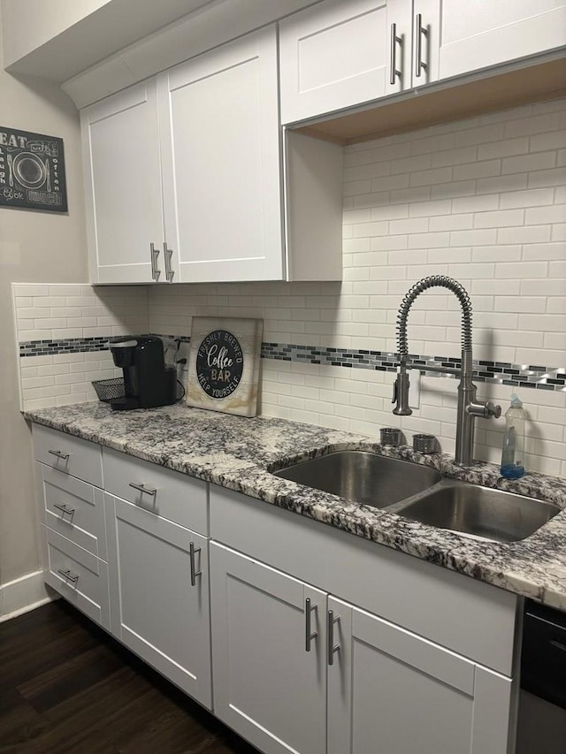 kitchen with backsplash, dark hardwood / wood-style flooring, sink, and white cabinets