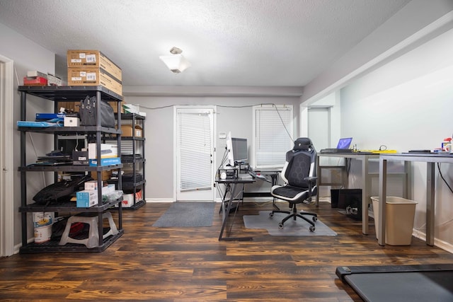 home office featuring a textured ceiling, baseboards, and wood finished floors