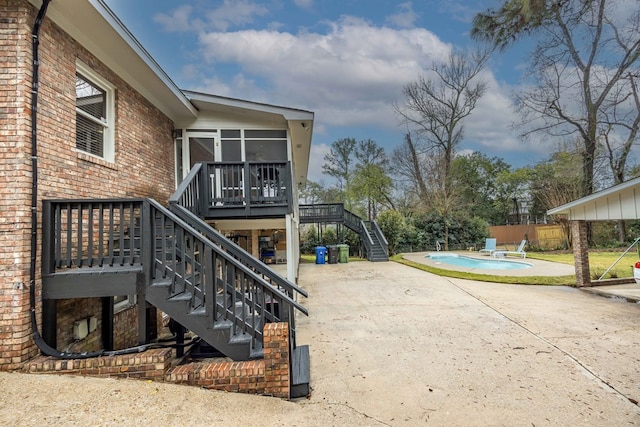 exterior space with fence, stairway, a wooden deck, a sunroom, and a fenced in pool