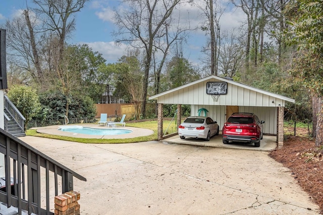 exterior space featuring a detached carport, a fenced in pool, concrete driveway, and fence