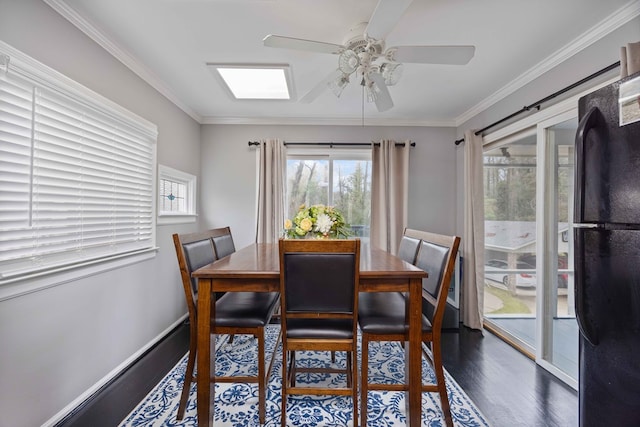 dining area featuring crown molding, wood finished floors, baseboards, and ceiling fan