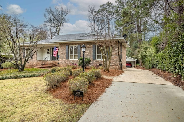 ranch-style house with an attached carport, a front lawn, brick siding, and driveway