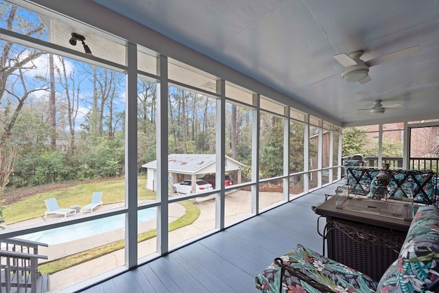 sunroom / solarium featuring a ceiling fan