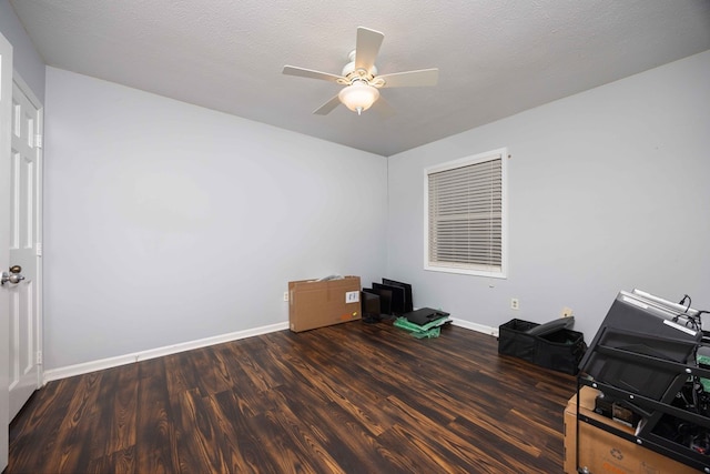 interior space with baseboards, wood finished floors, a textured ceiling, and ceiling fan