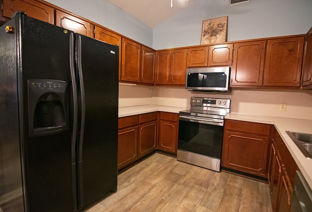 4200 Bridgecrest Dr Unit E4, Phenix City, AL 36867 - kitchen with appliances with stainless steel finishes, light wood-style floors, vaulted ceiling, and brown cabinetry
