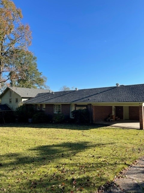 rear view of property with a lawn and a patio area