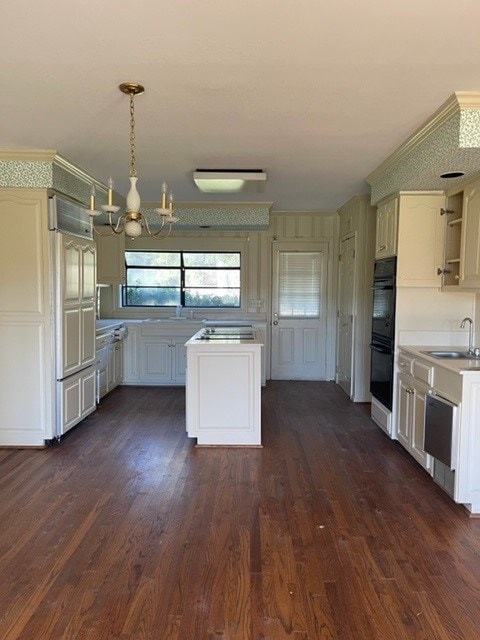 kitchen with sink, an inviting chandelier, dark hardwood / wood-style flooring, double oven, and pendant lighting