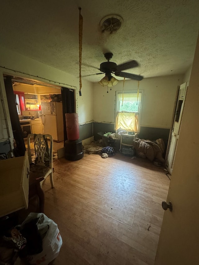 322 48th St, Columbus, GA 31904 - bedroom with a textured ceiling, wood finished floors, ceiling fan, and freestanding refrigerator