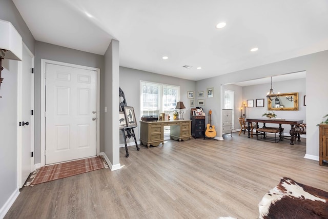 entryway featuring light hardwood / wood-style flooring and a chandelier