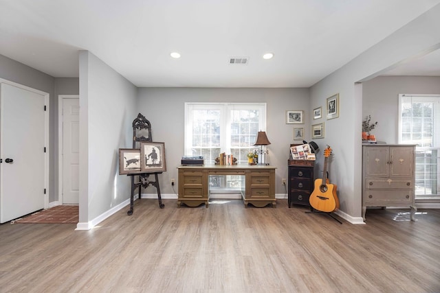 home office with light hardwood / wood-style floors