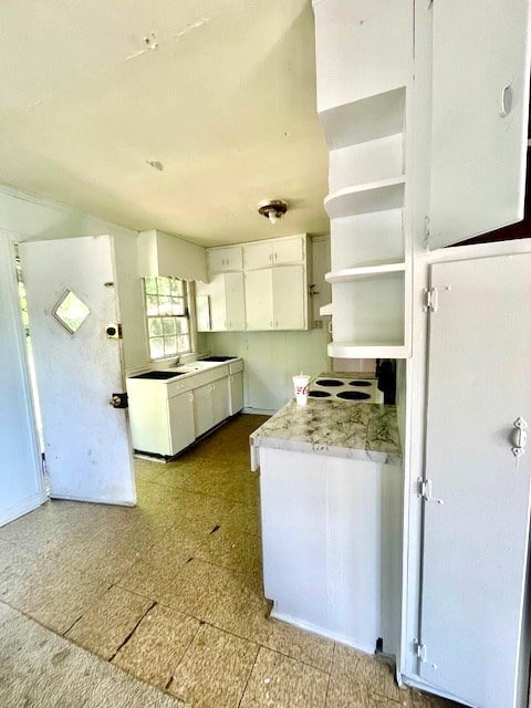 kitchen with white cabinetry and light stone counters