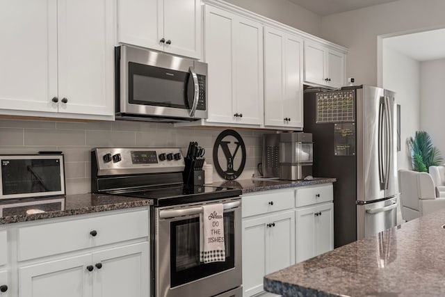 10 Red Maple St, Phenix City, AL 36869 - kitchen featuring appliances with stainless steel finishes, white cabinetry, decorative backsplash, and dark stone counters