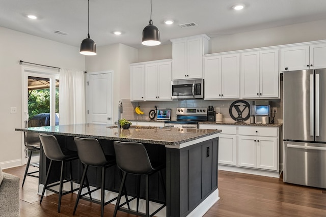 10 Red Maple St, Phenix City, AL 36869 - kitchen with stainless steel appliances, dark wood finished floors, backsplash, a center island with sink, and white cabinets