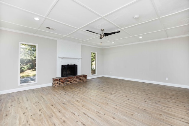 unfurnished living room featuring ceiling fan, ornamental molding, a fireplace, and light hardwood / wood-style flooring