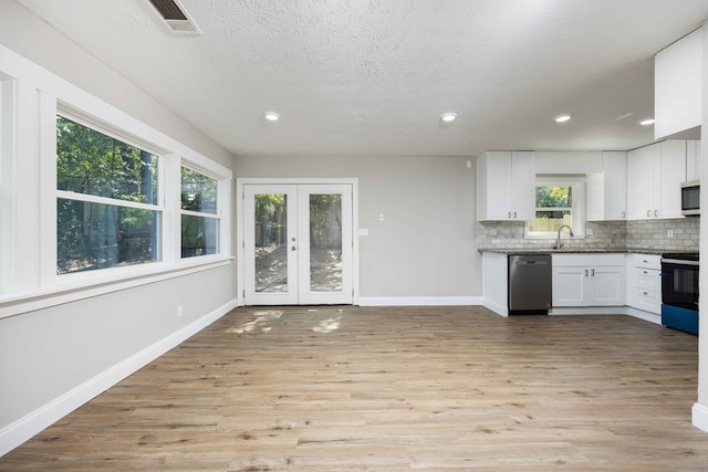 kitchen with light hardwood / wood-style flooring, white cabinetry, stainless steel appliances, and french doors