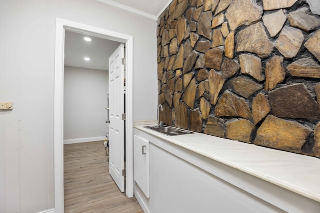 interior space featuring light hardwood / wood-style flooring, ornamental molding, and sink