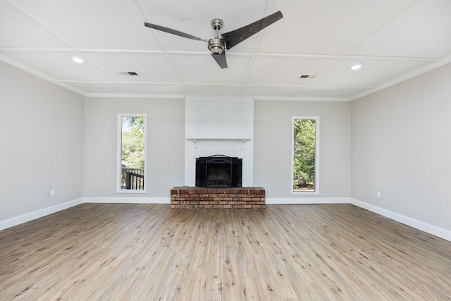 unfurnished living room featuring light wood-type flooring, a brick fireplace, plenty of natural light, and ceiling fan