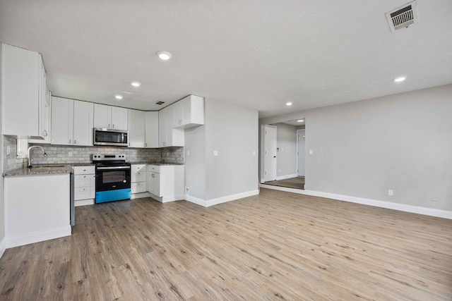 kitchen with white cabinetry, sink, stainless steel appliances, tasteful backsplash, and light hardwood / wood-style floors