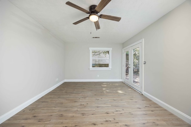 unfurnished room with ceiling fan, french doors, light hardwood / wood-style floors, and a textured ceiling