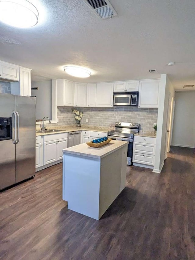 kitchen featuring white cabinets, dark wood-type flooring, and appliances with stainless steel finishes