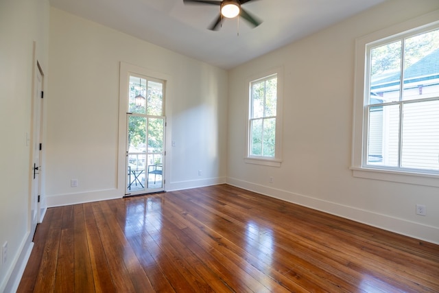 empty room featuring dark hardwood / wood-style floors, ceiling fan, and a healthy amount of sunlight