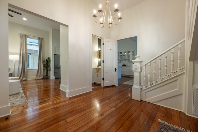 entryway with a high ceiling, dark hardwood / wood-style floors, and a notable chandelier