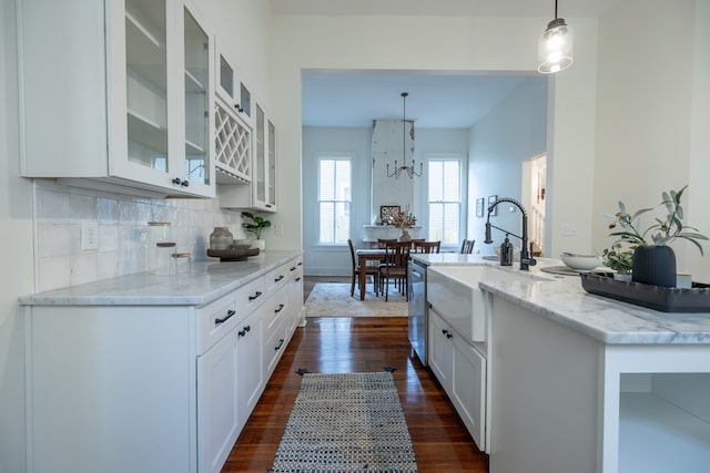 kitchen with light stone counters, sink, pendant lighting, dark hardwood / wood-style floors, and white cabinetry