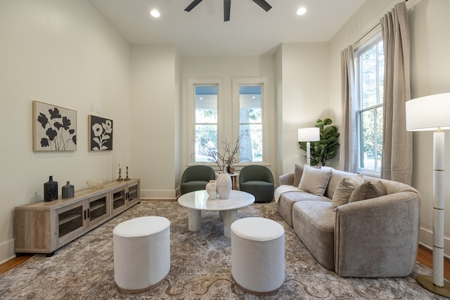 living area featuring hardwood / wood-style floors and ceiling fan