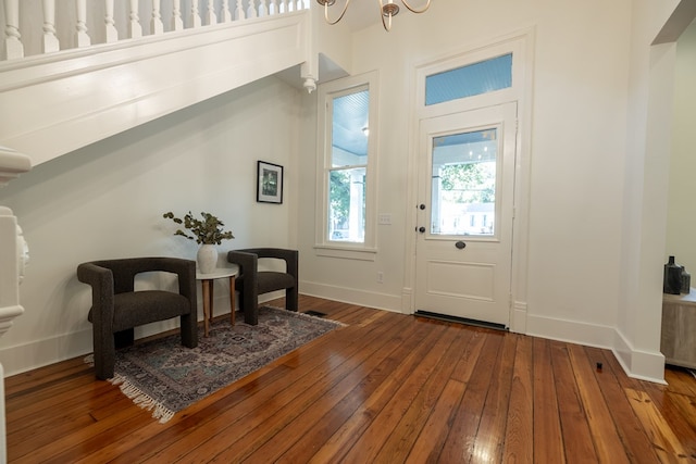 foyer entrance with an inviting chandelier and hardwood / wood-style flooring