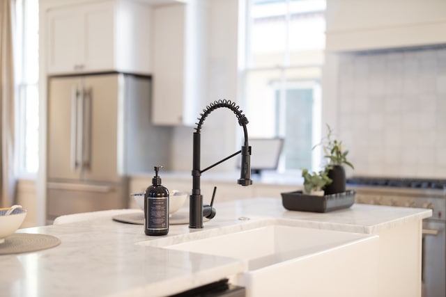 room details featuring white cabinetry, sink, and fridge