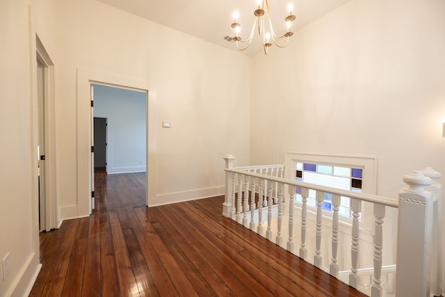 hall featuring dark hardwood / wood-style flooring and an inviting chandelier