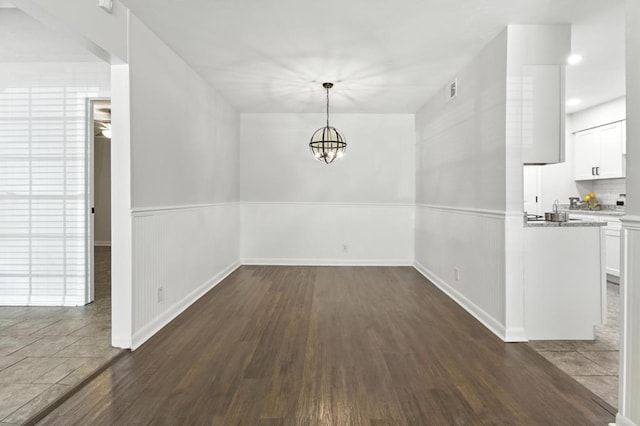 813 Wright Dr, Columbus, GA 31907 - unfurnished dining area with a wainscoted wall, dark wood-style floors, and a chandelier