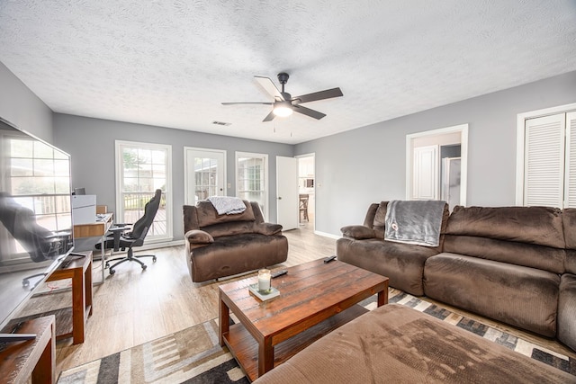 6909 Trapper Way, Midland, GA 31820 - living room featuring an office area, ceiling fan, wood finished floors, and a textured ceiling