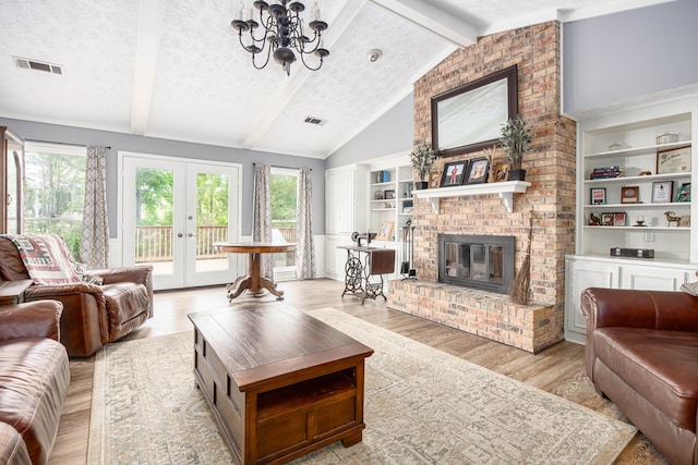 6909 Trapper Way, Midland, GA 31820 - living room with light wood-type flooring, plenty of natural light, a fireplace, a chandelier, and a textured ceiling