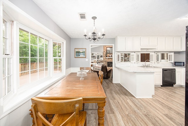6909 Trapper Way, Midland, GA 31820 - dining area with a chandelier, light wood finished floors, and a textured ceiling