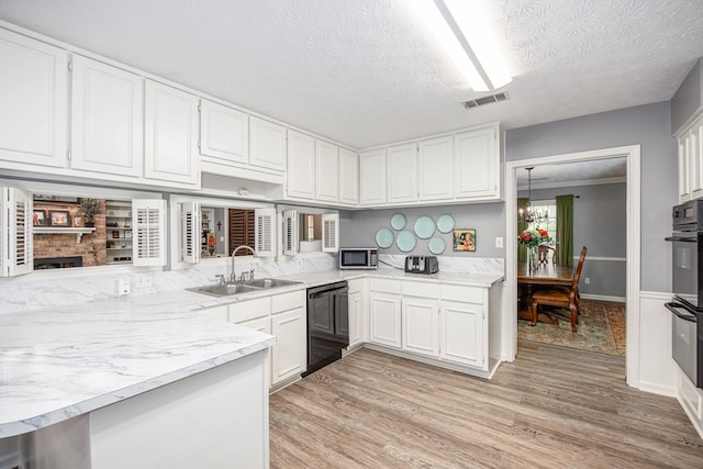 6909 Trapper Way, Midland, GA 31820 - kitchen featuring black appliances, white cabinets, light wood-type flooring, a textured ceiling, and a chandelier