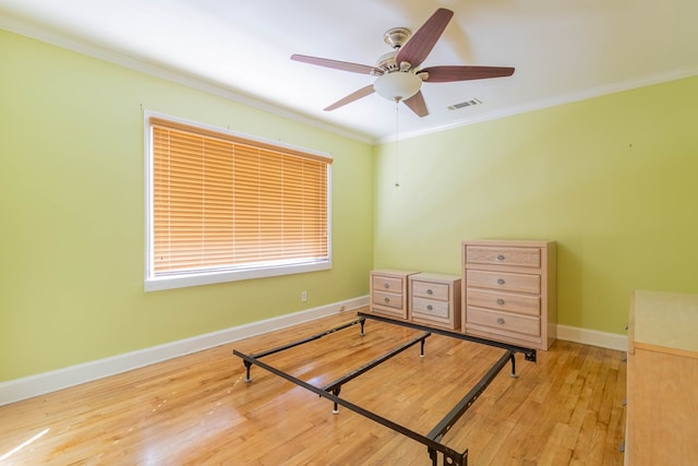 bedroom with visible vents, baseboards, a ceiling fan, wood-type flooring, and ornamental molding