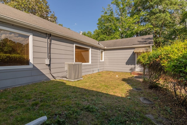 view of side of home featuring a yard and central AC unit