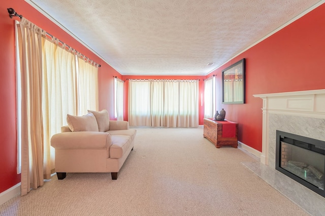 living area with a premium fireplace, ornamental molding, carpet flooring, a textured ceiling, and baseboards