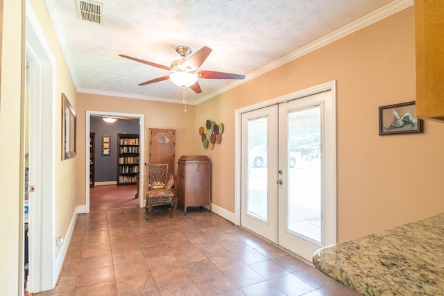 entryway with a textured ceiling, french doors, and crown molding