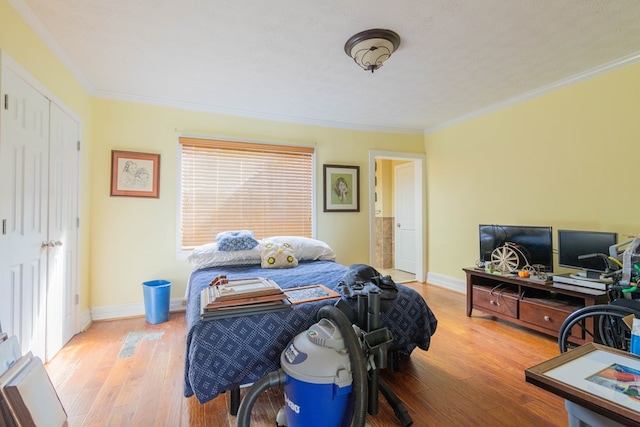 bedroom featuring crown molding, baseboards, and hardwood / wood-style flooring