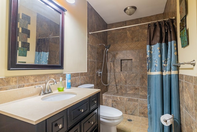 bathroom featuring toilet, a tile shower, and tile walls