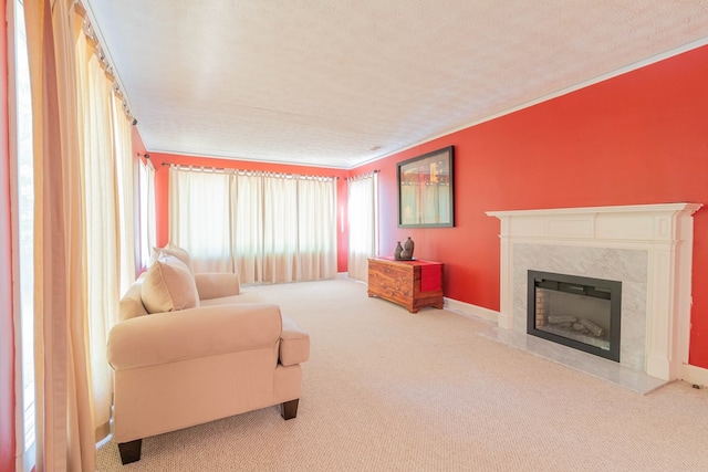 living area with a textured ceiling, a premium fireplace, ornamental molding, and carpet flooring